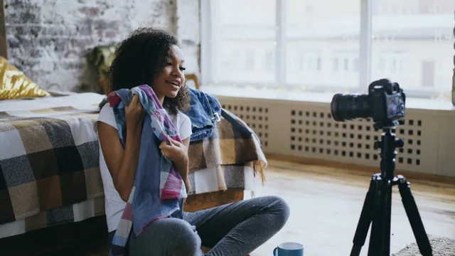 A young woman creates a fashion vlog in a cozy bedroom setting. Influencer lifestyle. Buying UGC content for brand campaigns