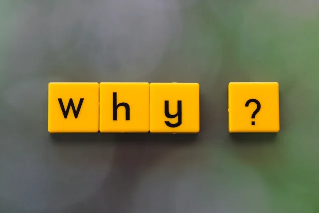 Yellow letter tiles spelling 'why?' create a thought-provoking scene on a green blurred background. Comparing question hooks with demonstration hooks