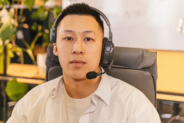 Focused young man with headset in a modern office setting. Sourcing genuine customer contributions